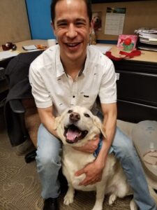 Man sitting with a happy white dog in his lap